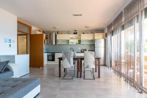 a kitchen and dining room with a table and chairs at Villa Orka in Omišalj