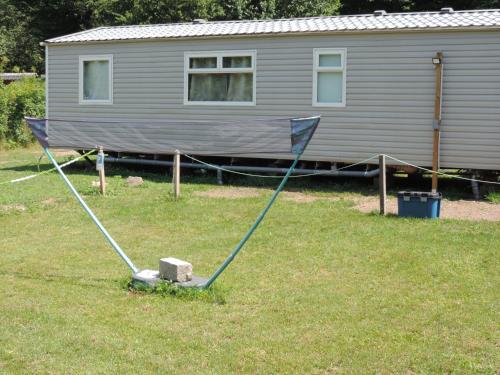 a large flag pole in the grass in front of a house at Emeraude aux 1000 Etangs in Belonchamp