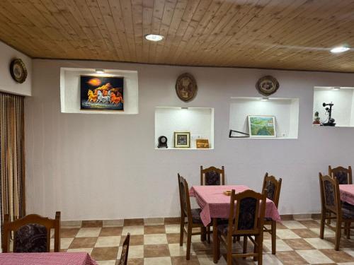 a dining room with pink tables and chairs and a wall at Resort Komovi in Kravlja