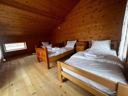 a bedroom with two beds in a wooden cabin at Resort Komovi in Kravlja