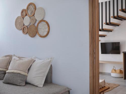 a living room with a couch and plates on the wall at Le Palme Mykonos in Klouvas