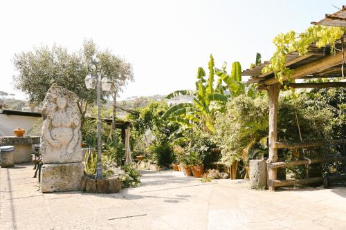 a garden with a statue in the middle of a sidewalk at Hotel Villa Cimmentorosso in Ischia