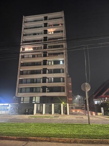 a tall building at night with its lights on at Alto Llaima Suites in Temuco