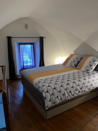 un letto in una camera da letto con finestra di Petite maison a Les Bondons
