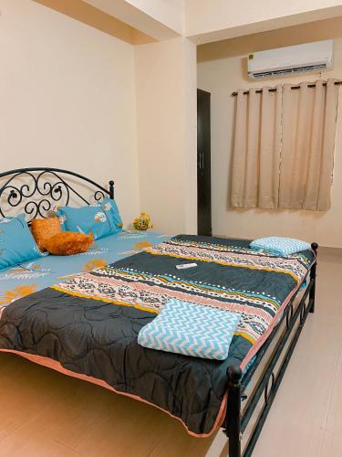 a bedroom with a bed with blue pillows on it at GOAROUND - Neo Villas at Vagator by Goaround Homes in Vagator