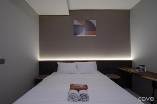 a bedroom with a bed with two shoes on it at Cove Vaia in Bandung