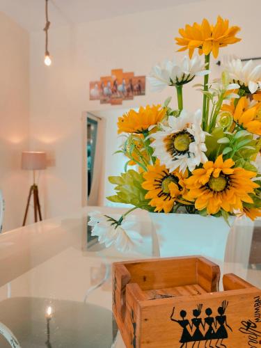 a vase filled with yellow and white flowers on a table at GOAROUND - Neo Villas at Vagator by Goaround Homes in Vagator