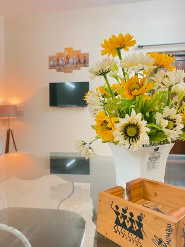 a vase filled with yellow and white flowers on a table at GOAROUND - Neo Villas at Vagator by Goaround Homes in Vagator