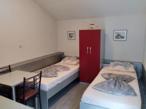une chambre avec deux lits et une armoire rouge dans l'établissement Apartment-Studio Downtown Dudanovi Ohrid, à Ohrid