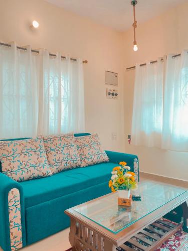 a living room with a blue couch and a table at GOAROUND - Neo Villas at Vagator by Goaround Homes in Vagator