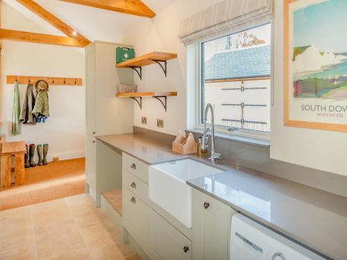 a kitchen with a sink and a window at Windover Barn in Slinfold