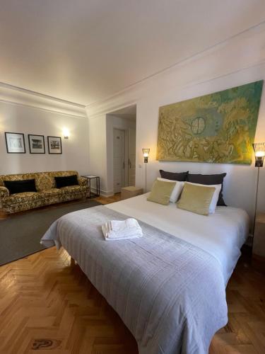 a bedroom with a large white bed and a couch at Suites Vintage in Lisbon