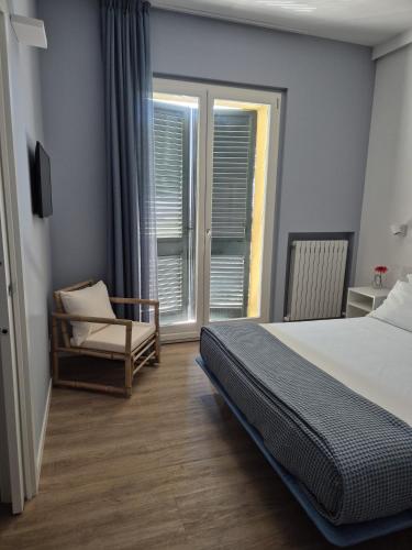 a bedroom with a bed and a chair and a window at La Cicada in Camerano