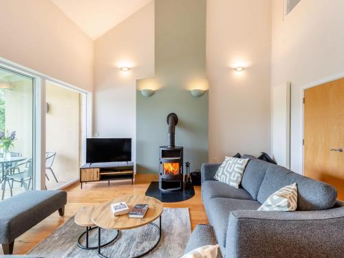 een woonkamer met een bank en een open haard bij Plovers Nest At Lower Mill in Somerford Keynes