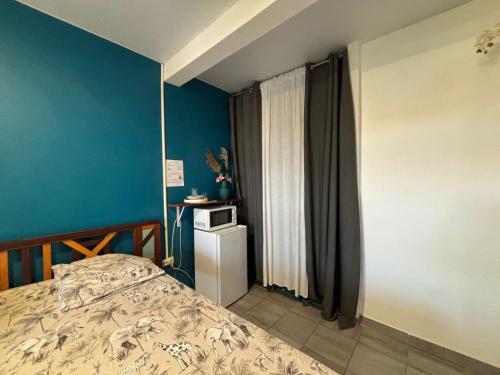 a bedroom with a bed and a blue wall at 84Rooms in Cayenne