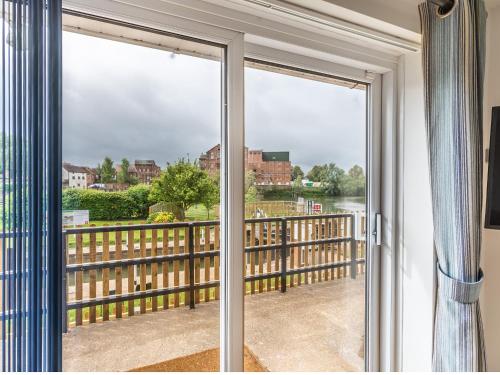 eine Glasschiebetür mit Blick auf einen Balkon in der Unterkunft Avon Lock Cottage - Uk34125 in Tewkesbury