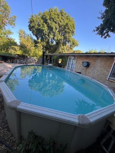 une grande piscine à l'arrière d'une maison dans l'établissement Chambre chez l habitant petit déjeuner compris, à Fréjus
