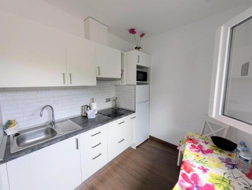 a kitchen with white cabinets and a sink and a window at CHC-Casa Cira in Los Silos