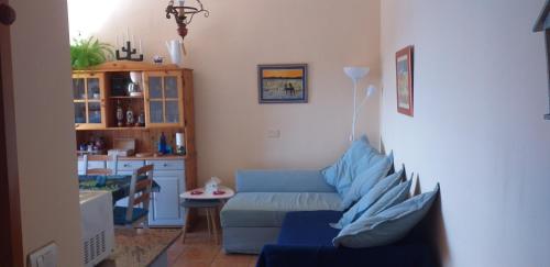 a living room with a blue couch and a table at Marjul in Garachico