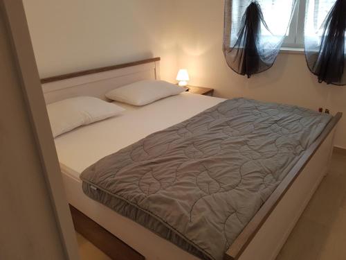 a bed in a small room with a bedskirtspectspectssenalsenalsenalsenal at Apartments Tereza in Senj