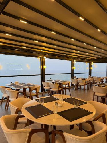 a restaurant with tables and chairs on a ship at Class Premium Suit Otel in Mersin
