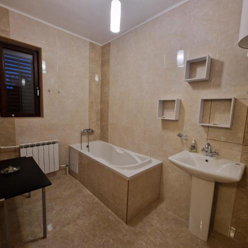 a bathroom with a bath tub and a sink at D&D Rooms 2 in Pula
