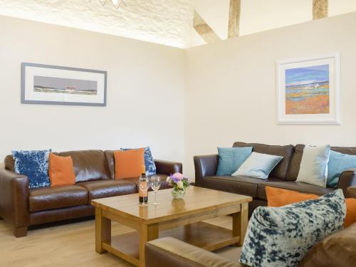 a living room with couches and a coffee table at The Garden Room At Eudon George in Shipton