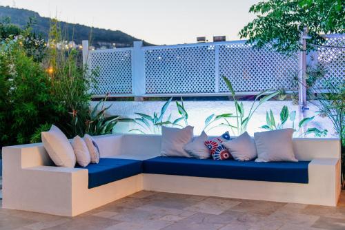a bench with pillows sitting on a patio at Via Farilya Hotel in Gundogan