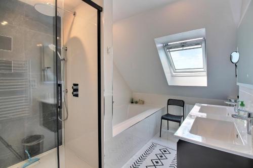 une salle de bain avec une baignoire, un lavabo et une douche dans l'établissement Maison spacieuse près des plages, à Combrit