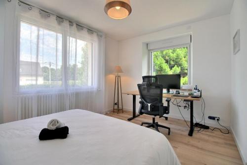 une chambre avec un lit et un bureau avec un ordinateur dans l'établissement Maison spacieuse près des plages, à Combrit