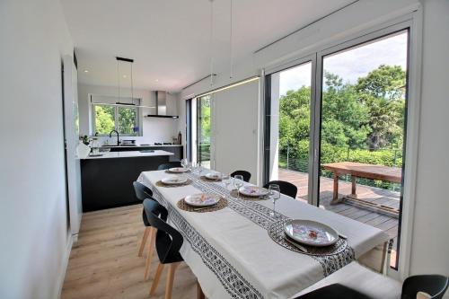 une cuisine et une salle à manger avec une table et des chaises dans l'établissement Maison spacieuse près des plages, à Combrit