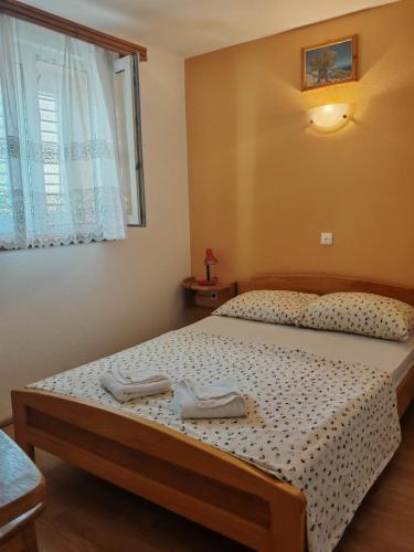 a bedroom with a bed with two towels on it at Mikulin Apartments in Lumbarda