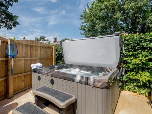 a hot tub in a yard with a chair at The Chicken Coop in Fulletby