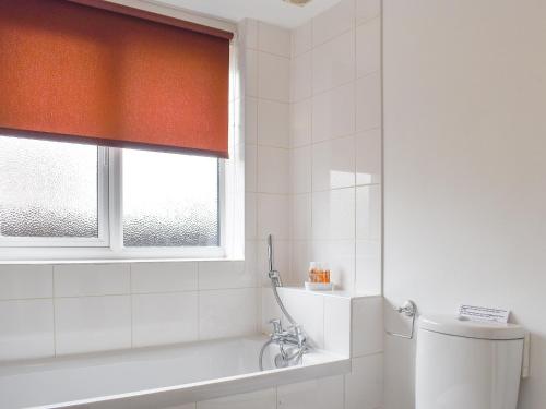 a bathroom with a toilet and a window at The Smithy in Crundale