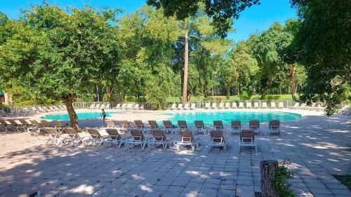 un groupe de chaises assises à côté d'une piscine dans l'établissement M-Golf 01-Moliets Maisonnette pour 6 personnes dans résidence avec piscine, à Moliets-et-Maa