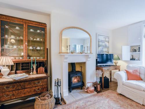 un soggiorno con camino e divano bianco di Hero Cottage a Holt