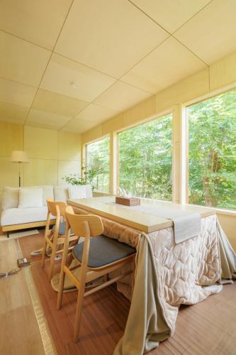 a room with a table and chairs and a couch at Cooee Yamanakako in Yamanakako