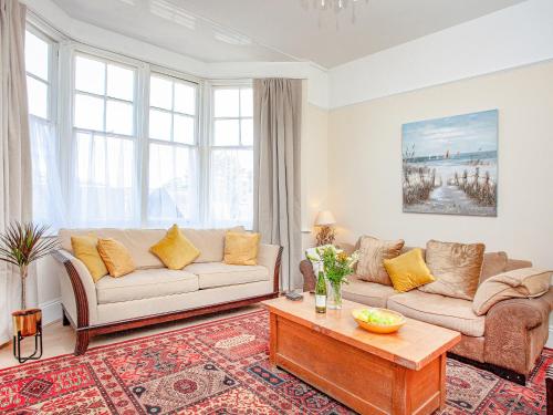 a living room with a couch and a table at The Coach House At Vane Hill in Torquay
