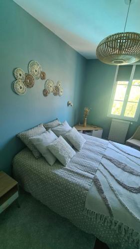 une chambre avec un lit avec un mur bleu dans l'établissement Charmante maison de ville en pierre avec piscine, à Eysines