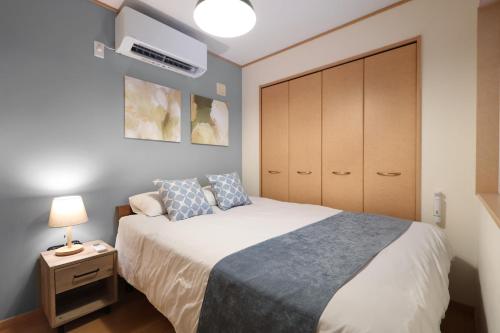 a small bedroom with a bed and a cabinet at Spacious Family Home Sleeps 13 Near USJ & Osaka Station in Osaka