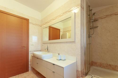 a bathroom with a sink and a mirror and a shower at AnnaLand in Padenghe sul Garda