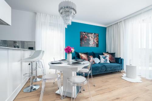 a living room with a blue couch and a table at Apartament AQUAMARIN Sarbinove Prestige by BALTIC CLUB in Sarbinowo