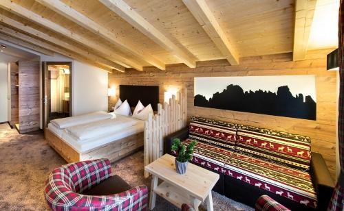 A bed or beds in a room at Hotel Chalet Dolomites