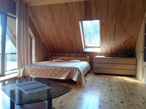 a bedroom with a bed and a glass table at Guest house Vilciņi in Bernāti