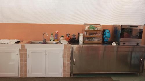 a kitchen with a sink and a counter with a microwave at Casa La Perla in Ischia