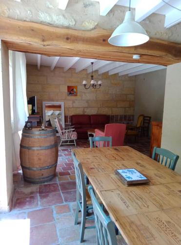 Cette chambre comprend une table en bois et un tonneau de vin. dans l'établissement Gîte du Vigneron - Nature et Vin, à Saint-Magne-de-Castillon