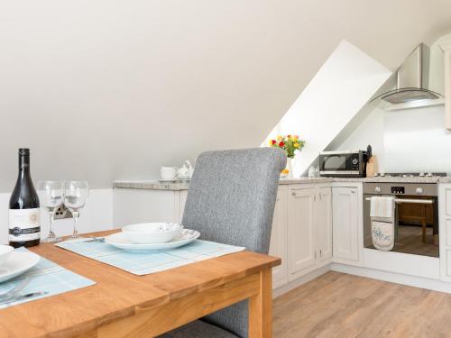 a kitchen with a wooden table with a chair at The Apple Loft in Mickleton