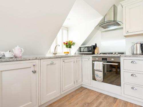a kitchen with white cabinets and a sink at The Apple Loft in Mickleton