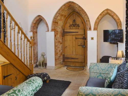 a living room with a wooden door and a tv at The Old Folly in Hunmanby