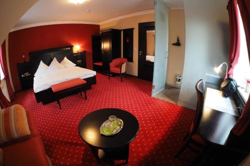 a hotel room with a bed and a table at Stelinger Hof Hotel Münkel in Hannover
